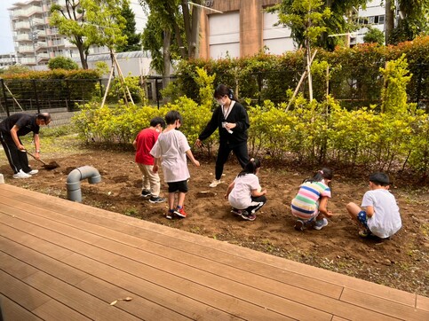 空きスペースに間隔をあけて子どもたちが種をまいている様子